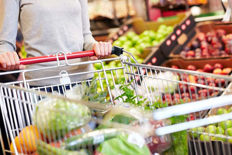 A close up of a shopping cart full of fresh produce.