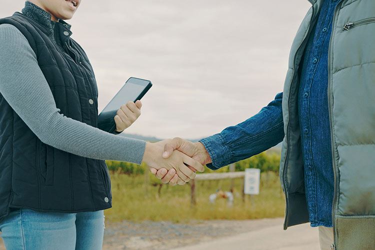 A close up of two growers shaking hands.